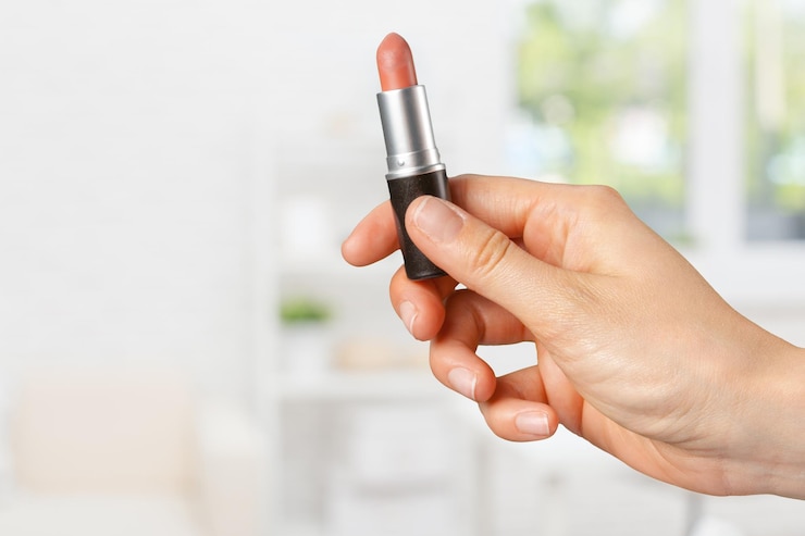 Foto la mano de la mujer sostiene el lápiz labial