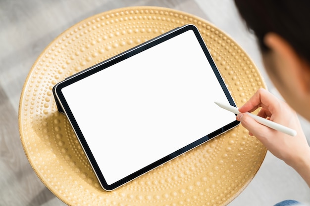 Foto mano de mujer con tableta digital y la pantalla está en blanco.