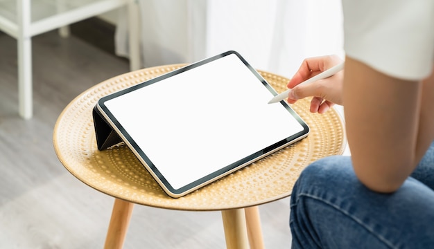 Foto mano de mujer con tableta digital y la pantalla está en blanco.