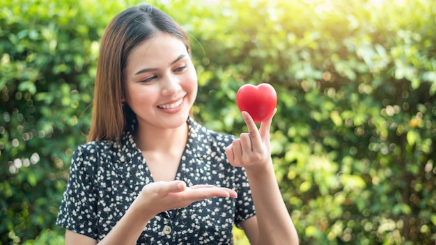 Mano de mujer tiene corazón rojo