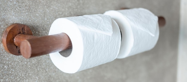 Foto mano de mujer tirando de papel higiénico en el baño. concepto de limpieza, estilo de vida e higiene personal.