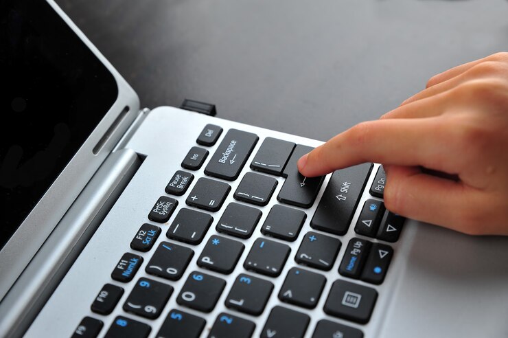 Foto mano de mujer tocando el teclado de la computadora portátil - centrarse en el teclado