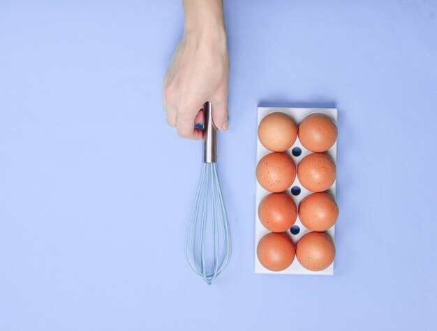 Mano de mujer tomando concepto culinario de batidor