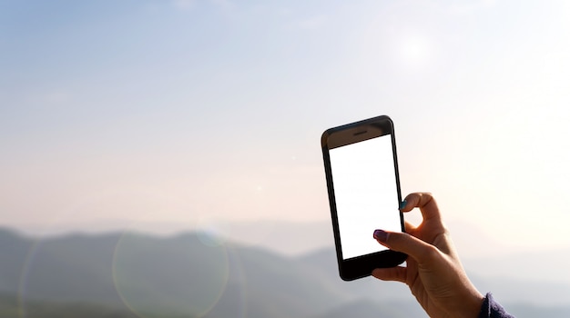 Mano de mujer tomando fotos de la naturaleza con teléfonos móviles.