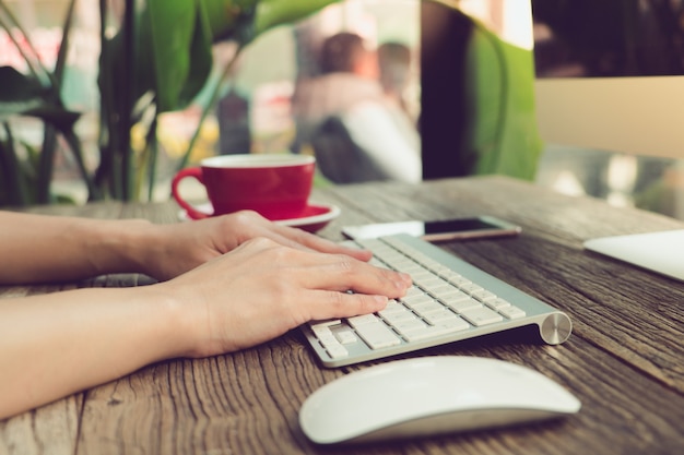 mano de mujer usando laptop buscando información en la cafetería