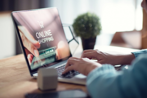 Mano de mujer usando laptop para compras pago en línea en casa.