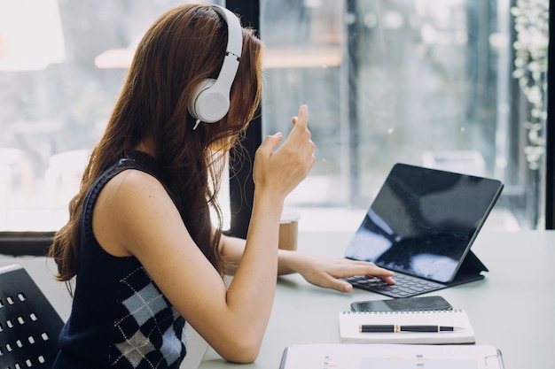 Mano de mujer usando un teléfono inteligente y una computadora portátil en el parque natural al aire libre y el cielo del atardecer con un fondo abstracto de luz bokeh Concepto de trabajo independiente y negocios de tecnología Estilo de color de filtro de tono vintage