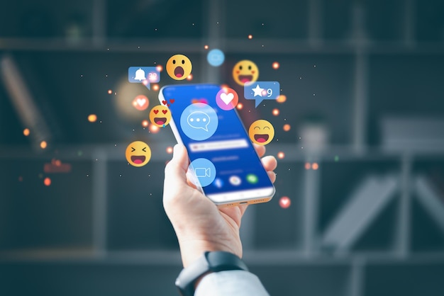 La mano de la mujer usando el teléfono inteligente y mostrando el icono de la tecnología de las redes sociales El concepto de la red social La mano usando el teléfono móvil con el icono De las redes sociales y la red social El concepto de marketing en línea
