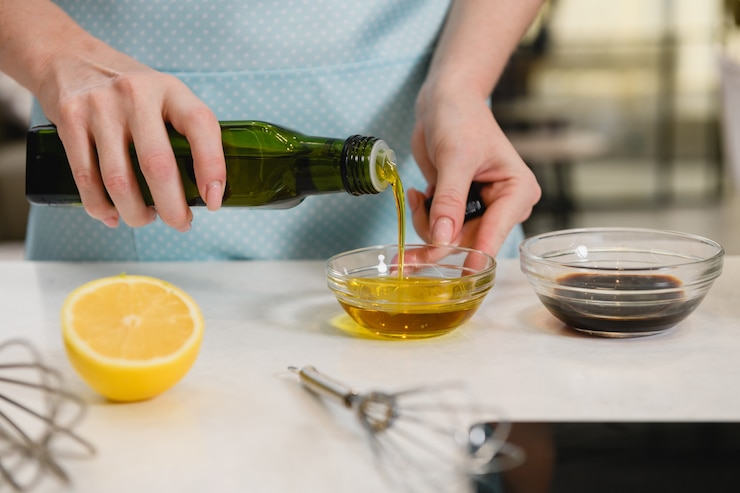 Foto mano de mujer vierte aceite vegetal en un tazón
