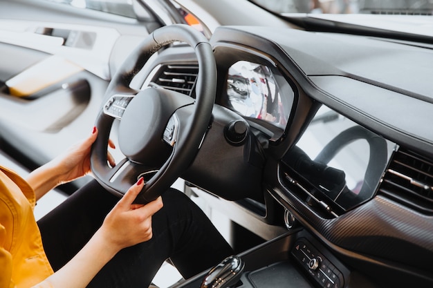 La mano de la mujer en el volante.