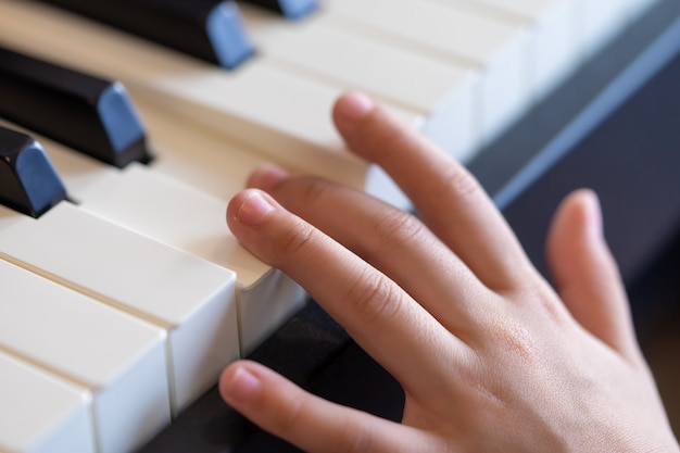 Mano de un músico de niños tocando el piano.