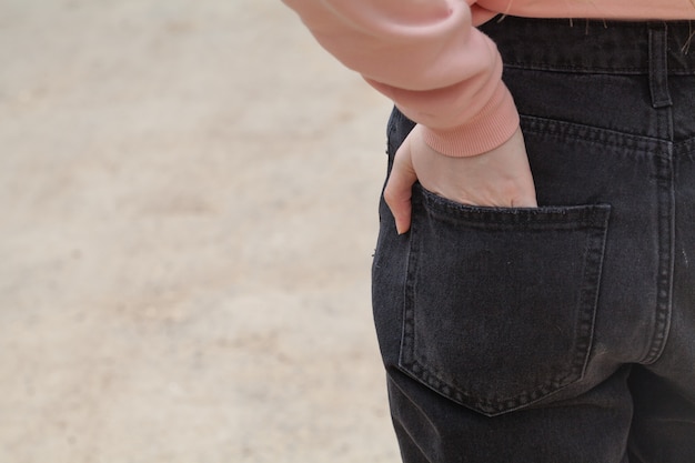 Foto la mano de la niña en el bolsillo trasero de los jeans.