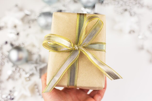 la mano de la niña sostiene una caja de regalo