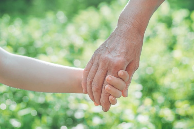 Mano de niño y abuela de mano vieja