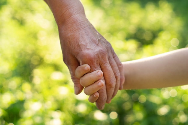 Mano de niño y abuela de mano vieja