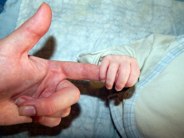 Foto la mano de un niño y un adulto