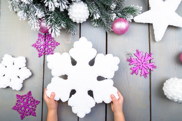 Mano de niño con copo de nieve decorativo de Navidad