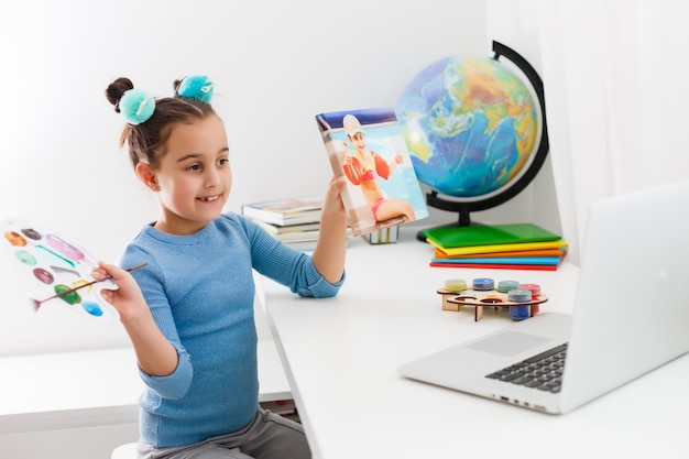 La mano del niño dibuja un lápiz de color. La educación a distancia