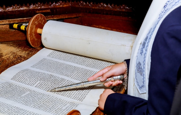 Mano del niño leyendo la Torá judía en el bar Mitzvah Bar Mitzvah Torá leyendo