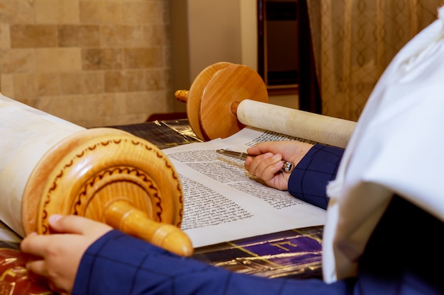 Mano del niño leyendo la Torá judía en el bar Mitzvah Bar Mitzvah Torá leyendo