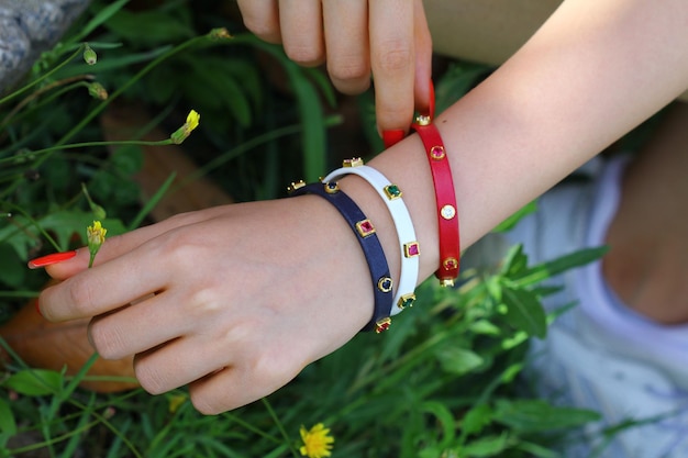 La mano de un niño lleva una pulsera con una banda roja y una banda roja.
