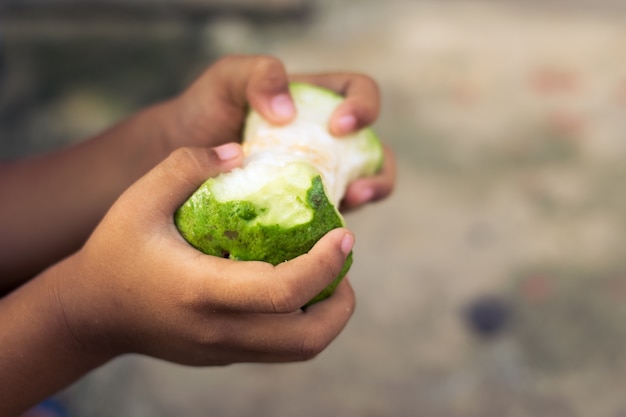 mano de niño pobre con fruta comido