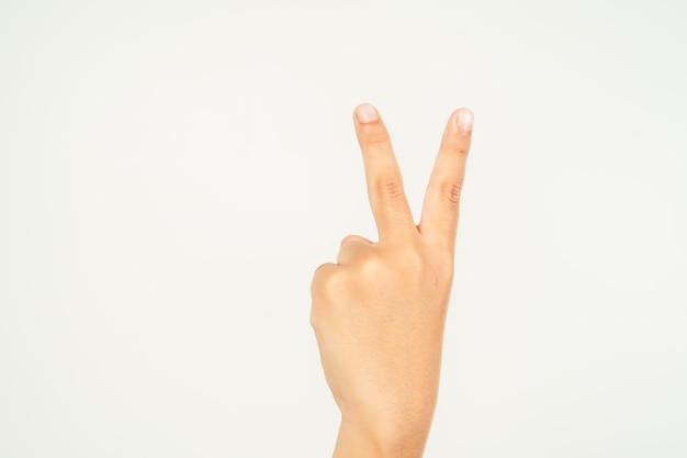 Foto mano del niño señalando con dos dedos mano mostrando el signo de paz aislado en fondo blanco