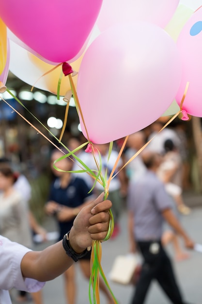 Mano de un niño sosteniendo un globos multicolores.