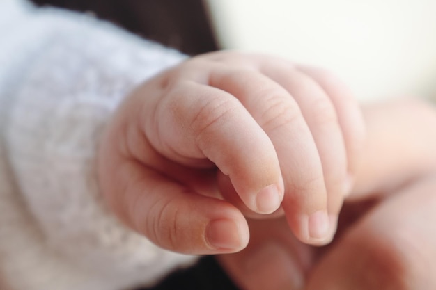 La mano del niño sostiene el dedo de la madre.