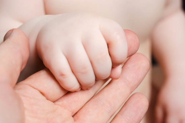 Mano de los niños sosteniendo la mano de su padre