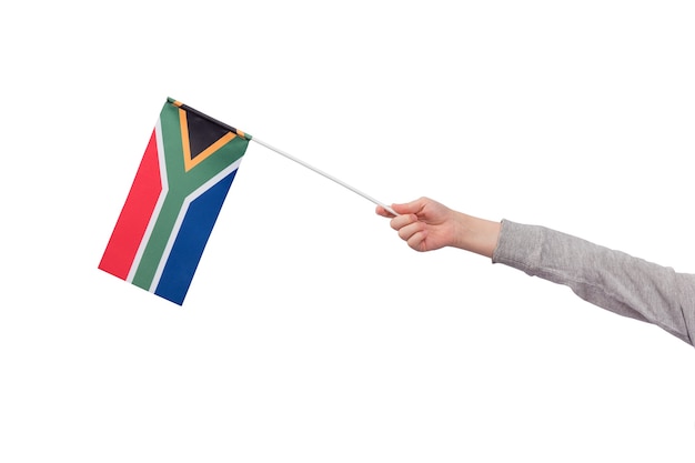 La mano de los niños sostiene la bandera de Sudáfrica aislado sobre fondo blanco. Bosquejo