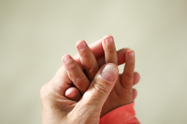 Mano de niños con uñas sucias en la mano de las madres antes de recortar