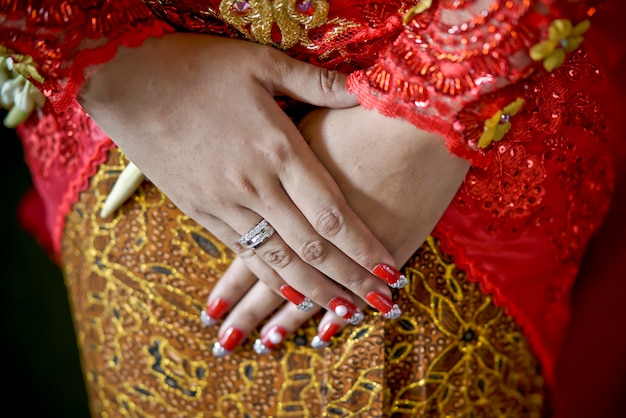 Foto la mano de la novia tradicional javanesa utilizando kebaya y batik de yogyakarta