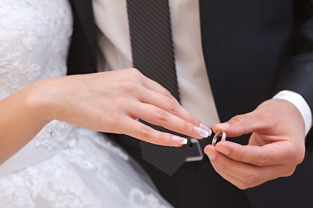 Mano del novio y la novia con anillos de boda en una fiesta de bodas