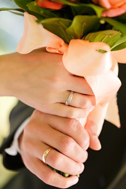Foto mano del novio y la novia con anillos de boda en una fiesta de bodas