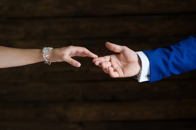 La mano del novio toca el primer plano de la mano de la novia