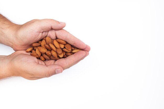 Mano con nueces de almendras peladas crudas grandes naturales