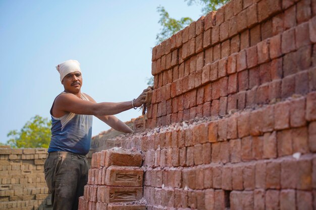 Mano de obra india trabajando en una fábrica de ladrillos