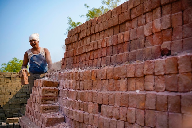 Mano de obra india trabajando en una fábrica de ladrillos