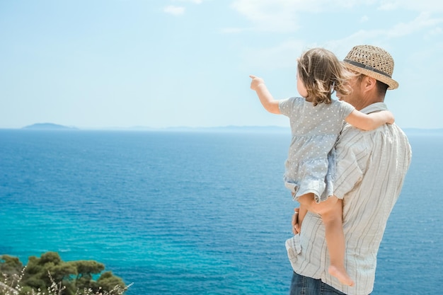 Una mano de padres y hijos felices en el mar en el fondo de viaje en Grecia