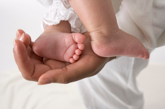 Mano de los padres que sostiene el pie pequeño del bebé