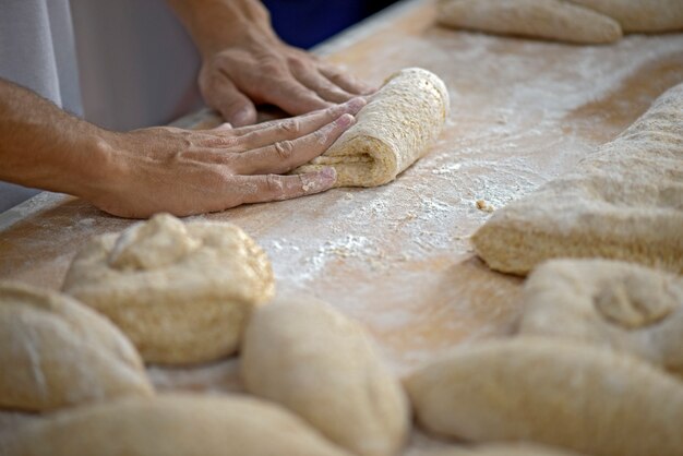 Mano de panadero moldeando panes para hornear