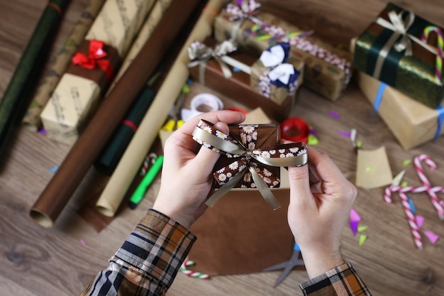 Mano papel de regalo para la cinta y lazos navideños