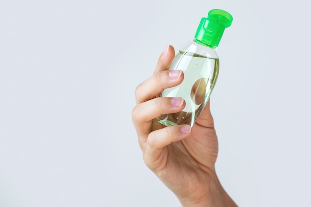 Mano con una pequeña botella de desinfectante para manos