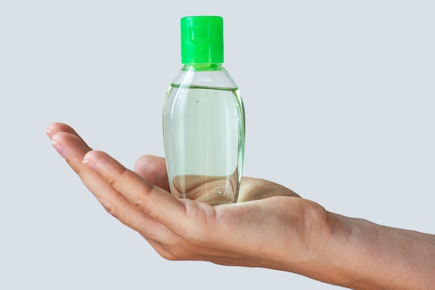 Mano con una pequeña botella de desinfectante para manos