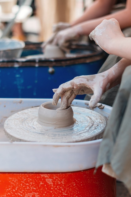 Foto la mano de una persona crea una figura de arcilla en cerámica.