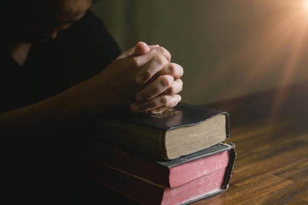 Mano de persona de oración en fondo negro Mujer católica cristiana está rezando a Dios en la oscuridad