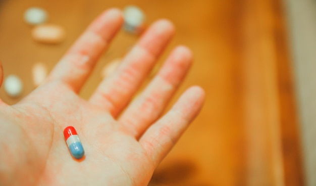 La mano de una persona con una pastilla azul