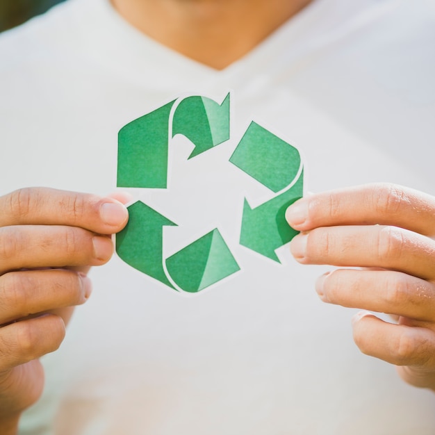 La mano de una persona que muestra el icono de reciclaje