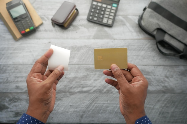 Mano de persona con tarjeta de crédito y papel de factura